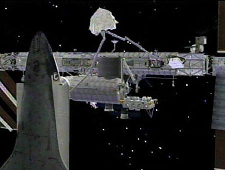 An artist's concept of the shuttle arm handing off the experiment carrier to the station's arm. Credit: NASA TV